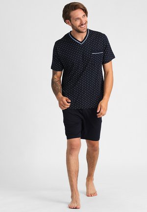 Marineblauwe short-sleeve shirt met kleine witte patronen, V-hals met lichtblauwe afwerking, gecombineerd met zwarte shorts, stof is glad en lichtgewicht.