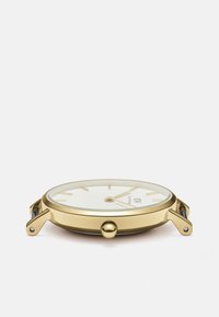 Goldene Uhr mit einem glatten, runden Gehäuse, weißem Zifferblatt, einfachen Stundenmarkierungen und einer Krone an der Seite zur Zeitanpassung.