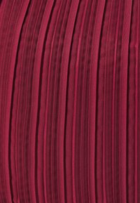 Tissu plissé de couleur bourgogne profond, présentant des plis verticaux régulièrement espacés avec une texture lisse et un éclat subtil, créant ainsi une apparence structurée.