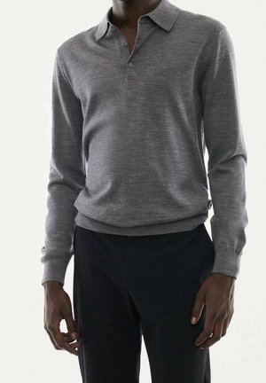 Grå langærmet polo-shirt med krave, der har en glat tekstur og en tætsiddende design; parret med sorte bukser.