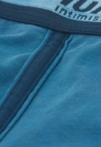Blaue Baumwoll-Boxershorts mit einem kontrastierenden dunkelblauen Bund, ausgestattet mit einer glatten Textur und genähten Details an der Vorderseite.