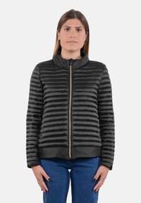 Giacca a vento nera con cuciture orizzontali, colletto alto e zip frontale. Texture liscia con dettagli minimi e un design leggero.