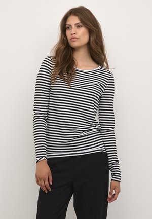 Black and white striped long-sleeve shirt with a round neckline. Ribbed texture and fitted design, paired with black pants.