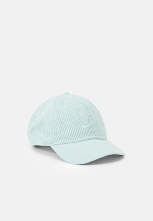 Casquette Nike en velours côtelé bleu clair avec une visière courbée et un logo brodé à l'avant, présentée sur fond blanc.