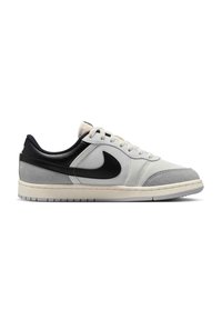 Χαμηλό sneaker σε λευκό και γκρι με μαύρο λογότυπο Nike, λευκά κορδόνια και πατούσα από κρεμ καουτσούκ σε λευκό φόντο.