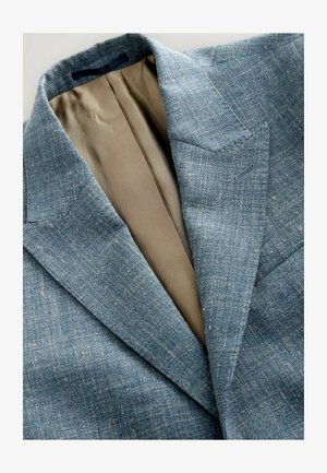 Textured blue blazer with a notched lapel, showcasing a light tan lining and subtle pattern, emphasizing a tailored fit and breathable material.