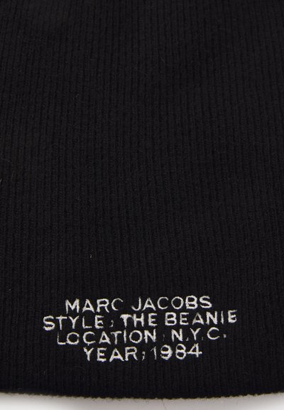 Black ribbed knit beanie featuring white embroidered text detailing the brand, style, location, and year: "MARC JACOBS, THE BEANIE, N.Y.C., 1984."