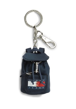 Mała ciemnoniebieska kluczka do kluczy w kształcie plecaka z przednią kieszenią na zamek i logo Tommy Jeans, przymocowana do srebrnego metalowego breloka i klipsa.