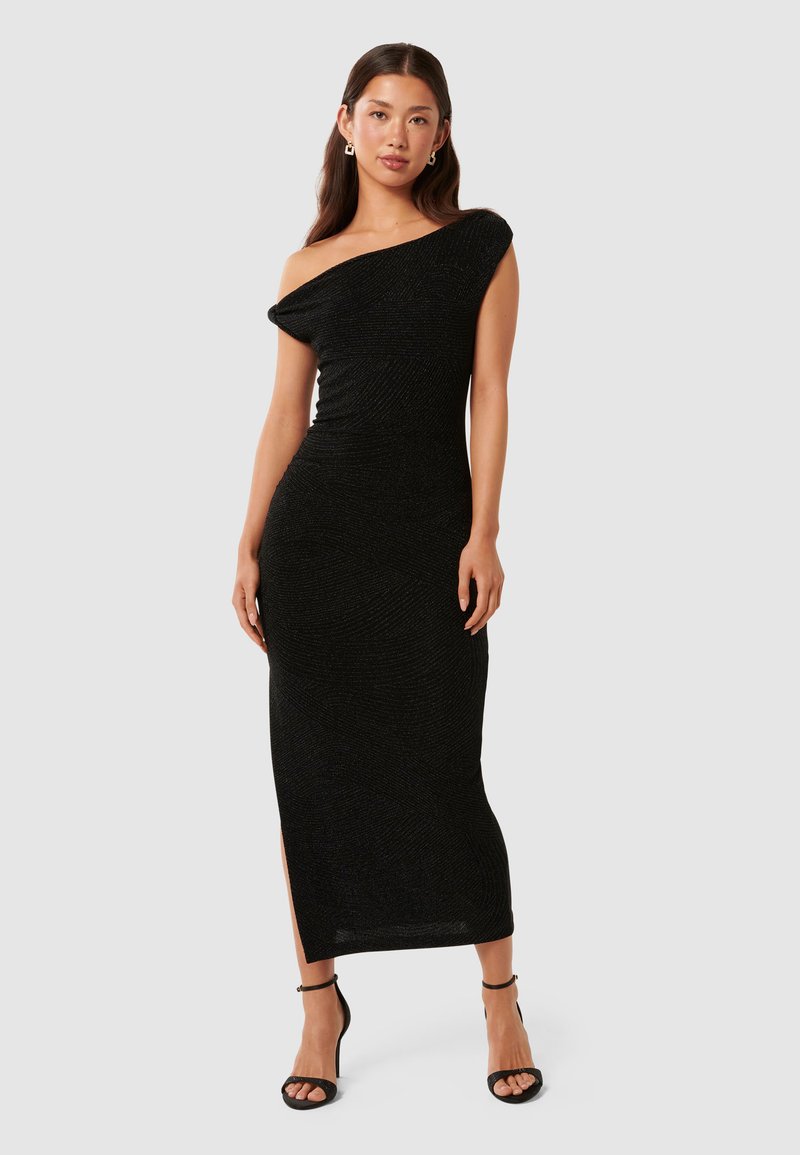 Rochie maxi neagră, cu umerii descoperiți, dintr-un material texturat, cu fante pe lateral și o siluetă ajustată. Purtați cu tocuri stiletto negre.