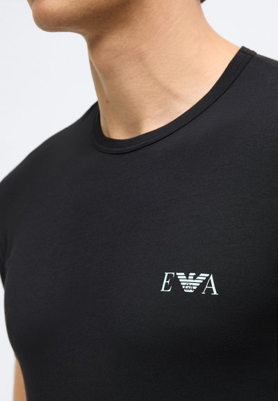 Black crew-neck t-shirt made from soft fabric. Features a small, white logo on the chest. Close-fitting design with smooth texture.