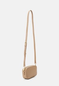 Beige crossbody bag laget av glatt lær med rektangulær form, justerbar stropp og detaljer i gullfarge. Minimalistisk design.