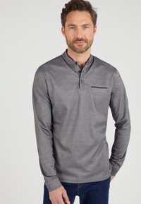 Grijs henley shirt met lange mouwen, knoopsluiting bij de kraag en een voorzak met een gemêleerd accent, gemaakt van een zachte, gladde stof.