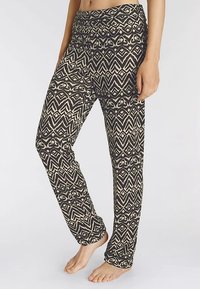 Broek met patroon heeft een geometrisch ontwerp in zwart en crème, zachte stof, brede tailleband en rechte pijp. Ideaal voor casual gebruik.