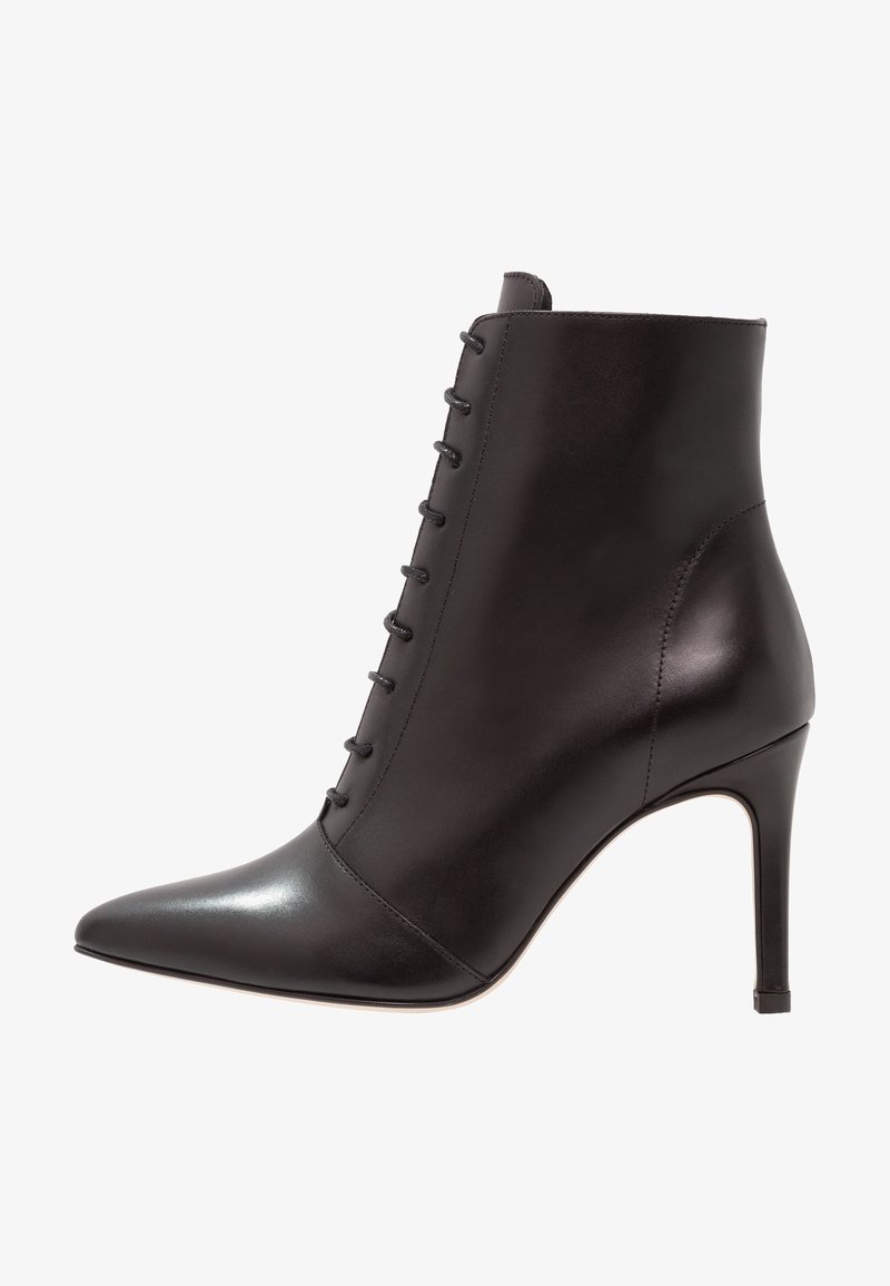 Bottine en cuir noir à bout pointu, lacets à l'avant et talon haut stilettos, vue de profil sur fond blanc.