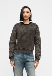 Σκούρο γκρι φούτερ με υφή, με ριμπ μανσέτες και στρογγυλή λαιμόκοψη. Διακοσμημένο με κάθετες ραφές στα μανίκια.