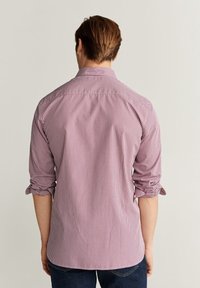 Camisa de botones con estampado de cuadros rojos y blancos, puños remangados, dobladillo recto y cuello clásico, vista desde atrás.