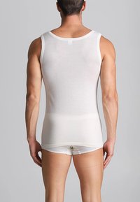 Top in cotone bianco senza maniche, con scollatura rotonda e vestibilità aderente, abbinato a mutande bianche in stile slip.