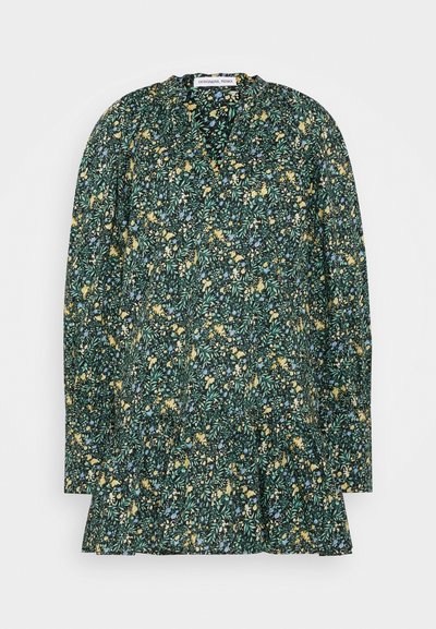 Blusa de estampado floral em verde escuro com mangas longas, apresentando flores amarelas e azuis, bainha plissada e um tecido suave e leve.