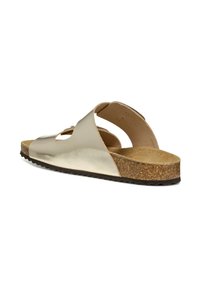 Sandal in oro metallizzato con punta aperta e ritagli sull'arco, soletta in sughero e suola in gomma testurizzata. Presenta una fascia posteriore per supporto.