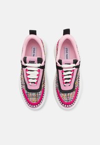 Zapatillas deportivas con un upper de tela tejida multicolor, acentos en rosa y negro, cordones blancos y una suela blanca gruesa. Incluye una lengüeta en el talón.