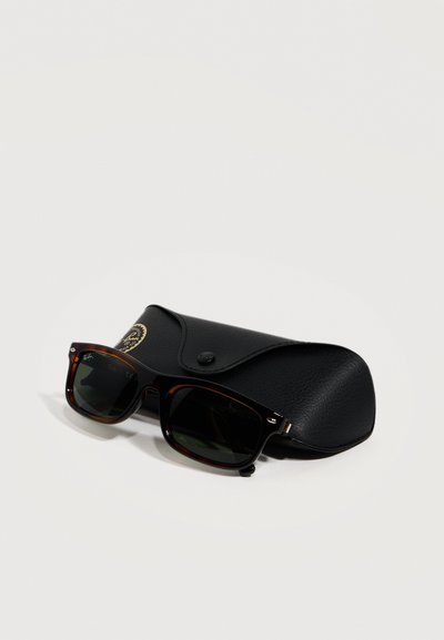 Слънчеви очила Ray-Ban Wayfarer с костенуркови рамки и тъмни стъкла, почиващи върху черен, текстуриран кожен калъф с копче за закопчаване.