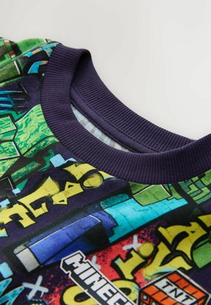 Trumpa rankovėmis, apvalia iškirpte marškinėliai su ryškiu Minecraft grafiniu atspaudų. Medžiagos apima audinį su lygiu paviršiumi; tamsiai mėlynas ribos apvadas.