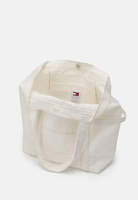 Canvas tote bag i off-white med öppen topp, dubbel platt handtag, innerficka och synlig sömnadsdetalj. Har varumärkesetikett inuti.