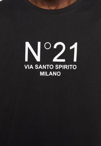 Czarna bawełniana koszulka z wyraźnym białym napisem "N°21 VIA SANTO SPIRITO MILANO" umieszczonym na środku przodu w nowoczesnej czcionce.
