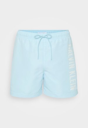 Heledad sinised ujumispüksid elastse vöökoha ja paelaga, vasakul küljel valge "CALVIN KLEIN" logo. Sile tekstuur ja lühike pikkus.