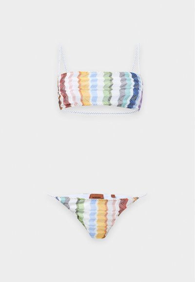 Bikini deux pièces avec des rayures horizontales multicolores en zigzag dans des nuances de rouge, jaune, bleu, vert et violet sur tissu blanc.