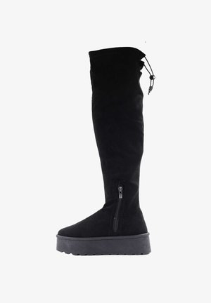 Czarne zamszowe buty za kolano na płaskiej, teksturowanej podeszwie, z zamkiem błyskawicznym z boku. Posiadają sznurek na górze do regulacji dopasowania.