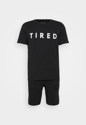 Black cotton t-shirt with “TIRED” in large white letters and matching black shorts, designed for comfort. Simple, casual fit.