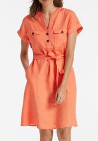 Vestido de lino coral con cuello con solapa, mangas cortas enrolladas, cierre delantero de botones, dos bolsillos en el pecho y cinturón anudado en la cintura.