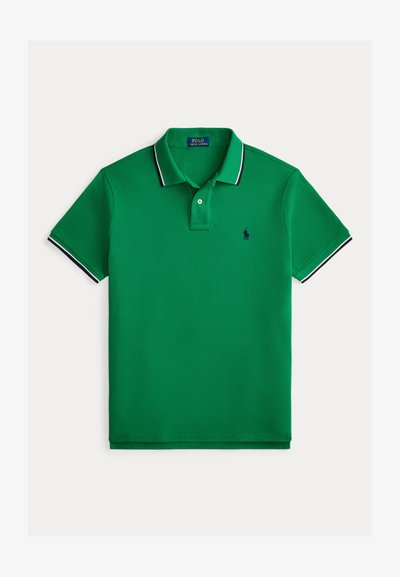 Polo vert en tissu texturé, avec une patte de boutonnage à deux boutons, un col et des accents de manches contrastants en bleu marine, ainsi qu'un petit logo.