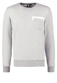 Felpa grigia realizzata in tessuto morbido, con una tasca bianca dotata di bottone a pressione, polsini e vita a coste. Design classico con collo a girocollo.