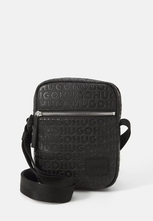 Borsa a tracolla rettangolare nera realizzata in materiale texturizzato, con marchio in rilievo, zip argentata e tracolla in tessuto intrecciato.