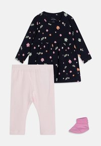 Námornícky šaty s kvetinovým vzorom, v páre s ružovými legínami a zodpovedajúcou ponožkou. Mäkký bavlnený materiál, okrúhly výstrih a dlhé rukávy.