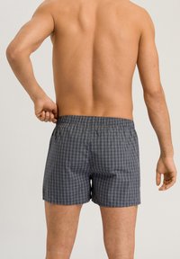 Męskie szorty w ciemnoniebieskim kolorze z pionowym wzorem w paski. Wygodny elastyczny pasek w talii, lekko luźny krój, wykonane z oddychającego materiału.