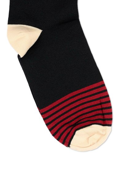 Chaussette noire avec des rayures horizontales rouges près des orteils, sections talon et orteils beige, texture en tissu tricoté.