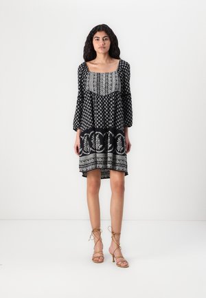 Vestido de estampado en blanco y negro con escote cuadrado, largas mangas abullonadas y dobladillo acampanado, que presenta intrincados diseños florales.