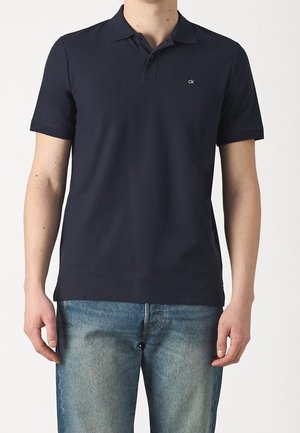 Marineblaues Poloshirt aus Baumwolle, mit einer Dreiknopfleiste und kleinem Logo auf der Brust. Kurzärmlig und in klassischer Passform.