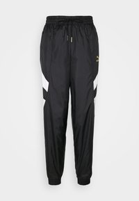 Svarta sportbyxor i lätt material med avsmalnande ben, elastisk midja och vita sidopaneler med en gyllene logotyp.