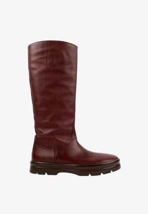 Botte haute en cuir marron foncé avec un bout arrondi et une épaisse semelle en caoutchouc noir, vue de côté sur fond blanc.