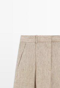 Beige linnen broek met riemlussen, zijzakken, plooien aan de voorkant en een verborgen knoopsluiting aan de voorkant.