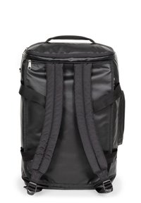 Musta reppu, jossa on karhennettu, vettä hylkivä ulkopinta, pehmustetut olkahihnat, vetoketjulla suljettava pää sekä päällihenkilö kantamista varten.