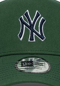 Πράσινο καπέλο με κεντημένο λογότυπο New York Yankees σε μπλε ναυτικό. Ρυθμιζόμενο κούμπωμα snapback με κυκλική ετικέτα New Era στο κάτω μέρος.
