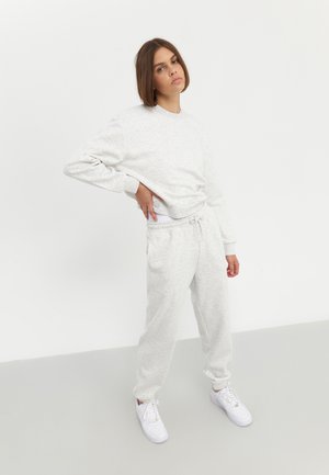 Helles graues Sweatshirt und passende Jogginghosen aus weichem Baumwollmix. Das Sweatshirt hat einen Rundhalsausschnitt; die Hose verfügt über einen elastischen Bund.