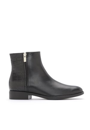 Bottine en cuir noir avec fermeture éclair latérale et motif crocodile texturé sur le talon, talon bas et bout arrondi.