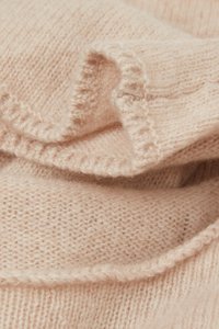 Mjuk rosa stickad tyg med ett fint, texturerat mönster. Har en lätt stretch och inrullade kanter som visar på ömtåliga söm detaljer.