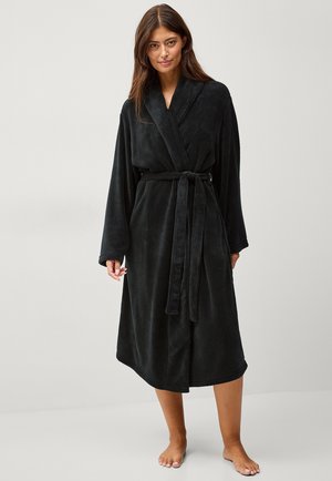 Schwarzer Fleece-Bademantel mit Wickeldesign, langen Ärmeln und passendem Gürtel. Weiche Textur und knielanger Schnitt.